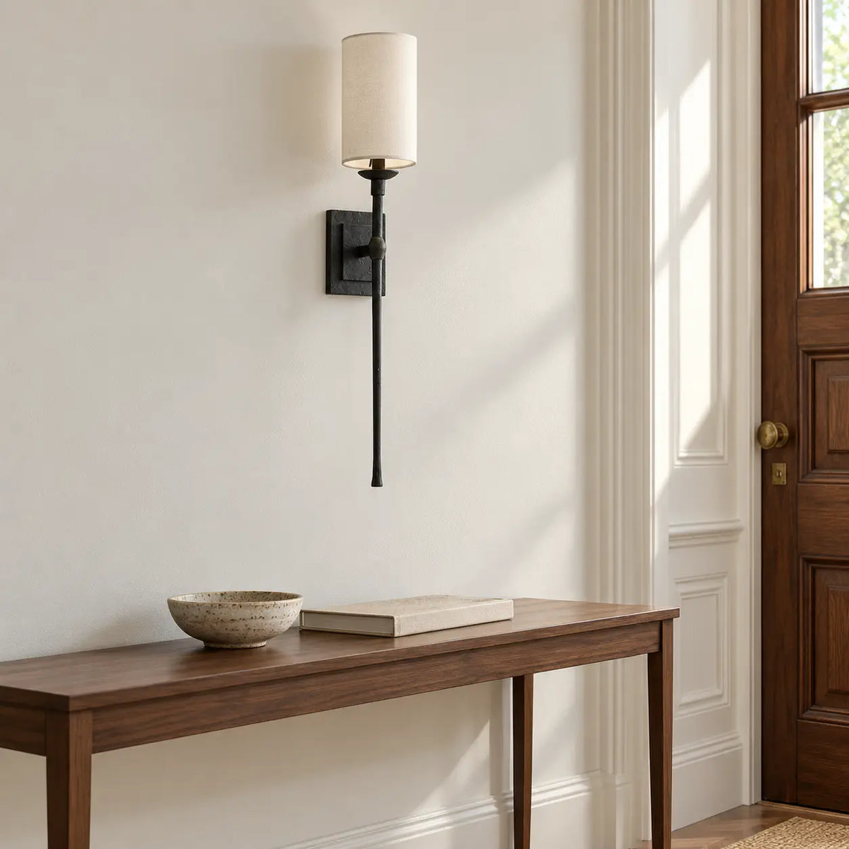 Black vertical rod wall light above an entry console
