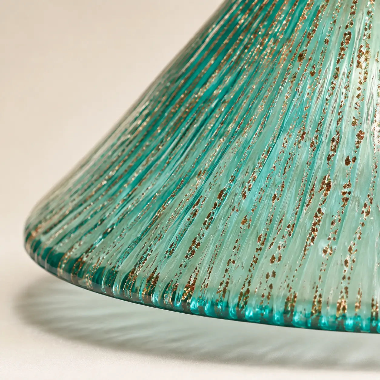 Close detail of peacock blue ribbed glass with gold flecks