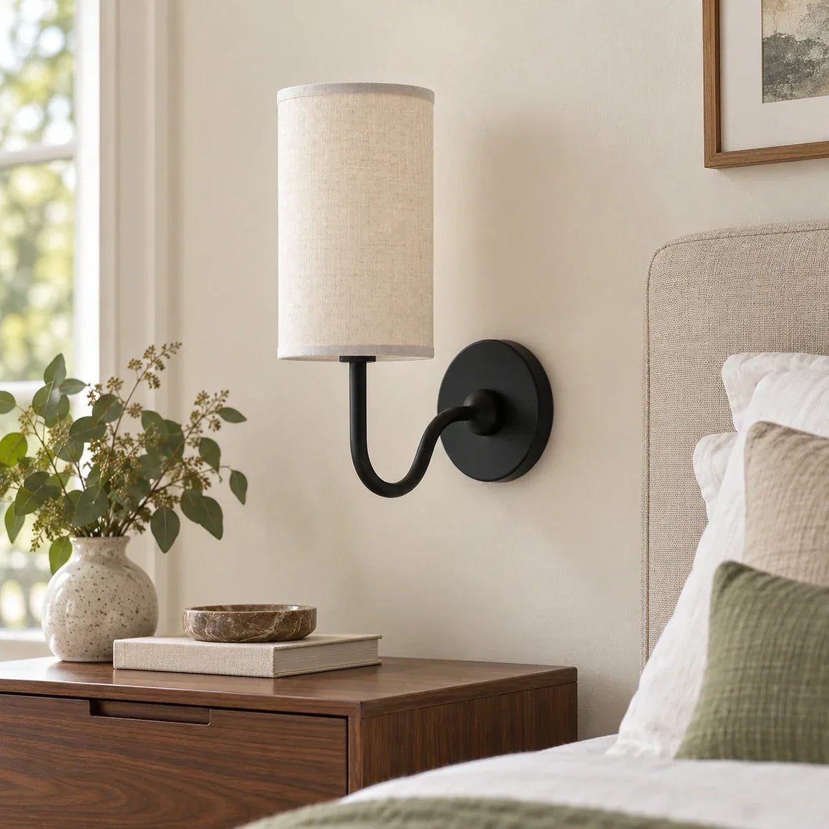 Black single wall light with white linen shade in a British interior