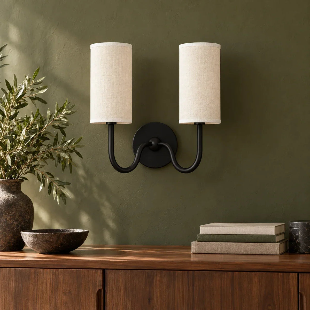 Black double wall light with white linen shade in a British interior