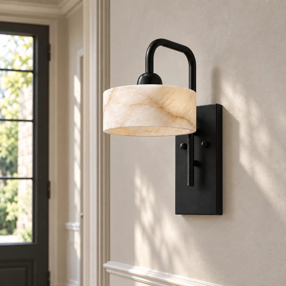 Straight alabaster wall light with matte black base in a bright hallway