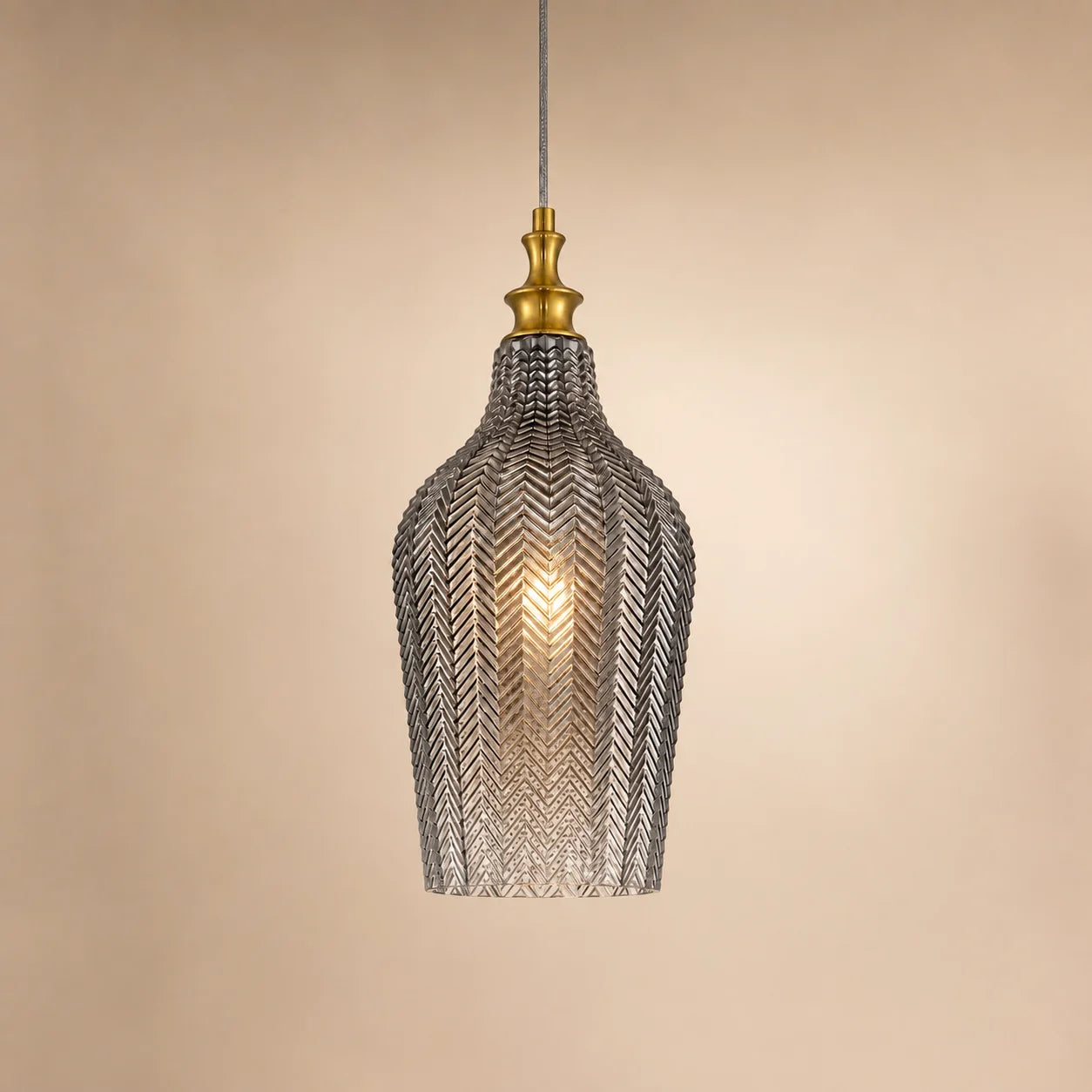 Tall smoke grey Solenne pendant light on a warm beige studio background