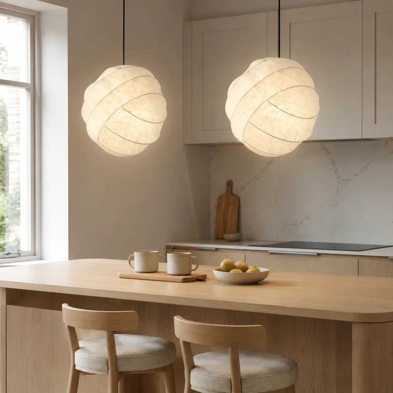 Pair of 50 cm ivory cocoon pendant lights above a kitchen island