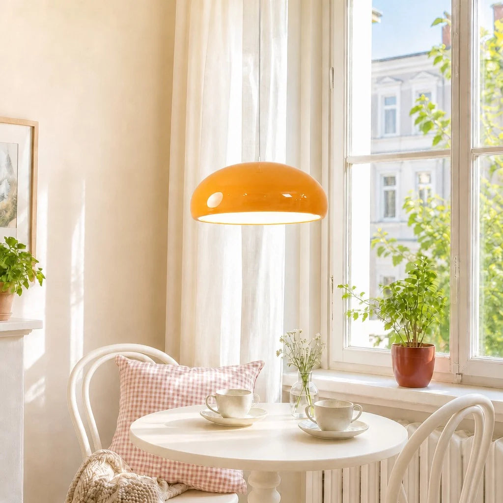 Brightly lit room with an orange lamp, white table, and chairs with a pink checkered pillow.