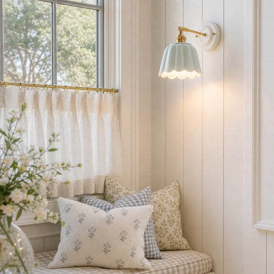 Nook with pillows, a window, and wall light fixture in a home interior.