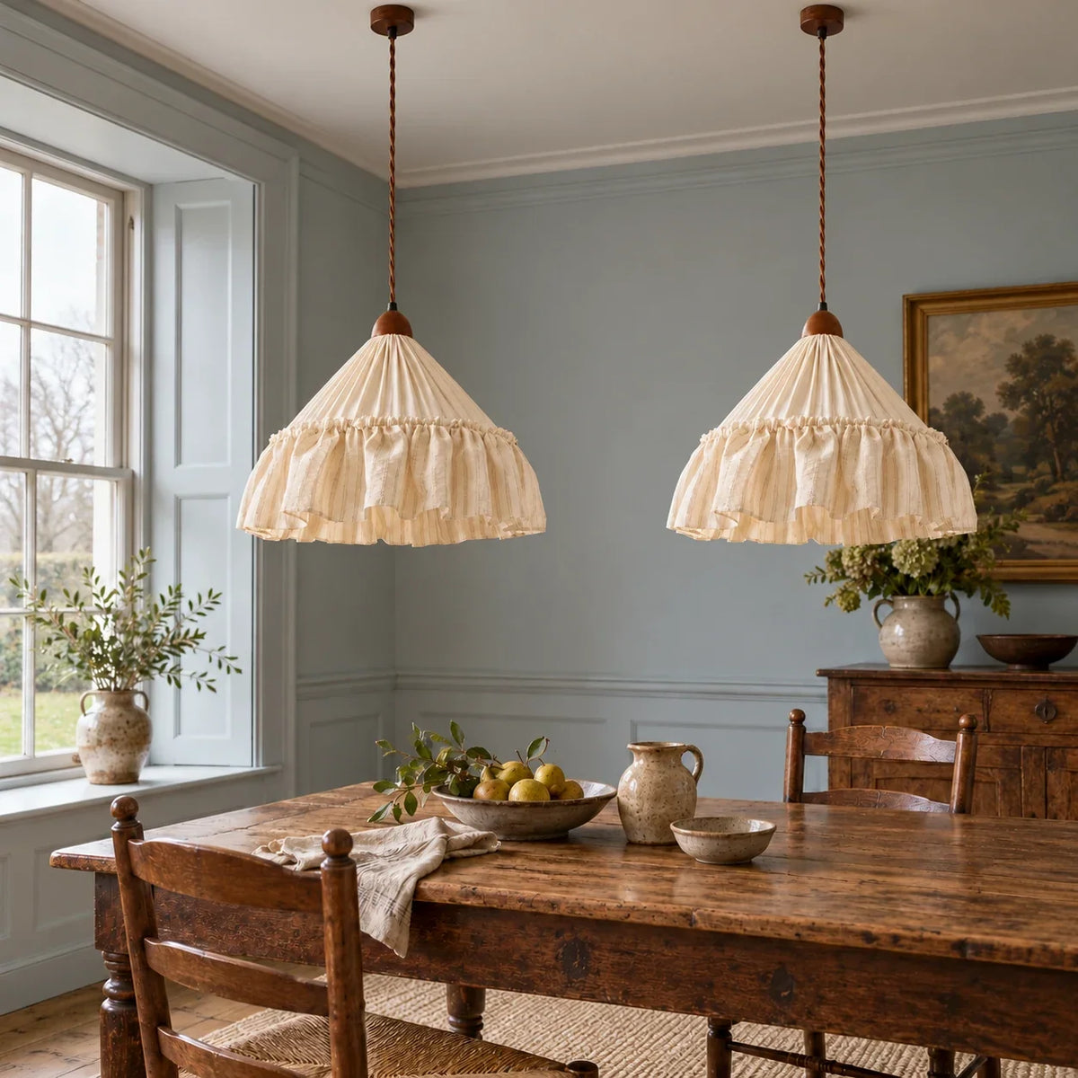 Two Apricot Stripe Amelie pendants over a long oak dining table; each sold separately