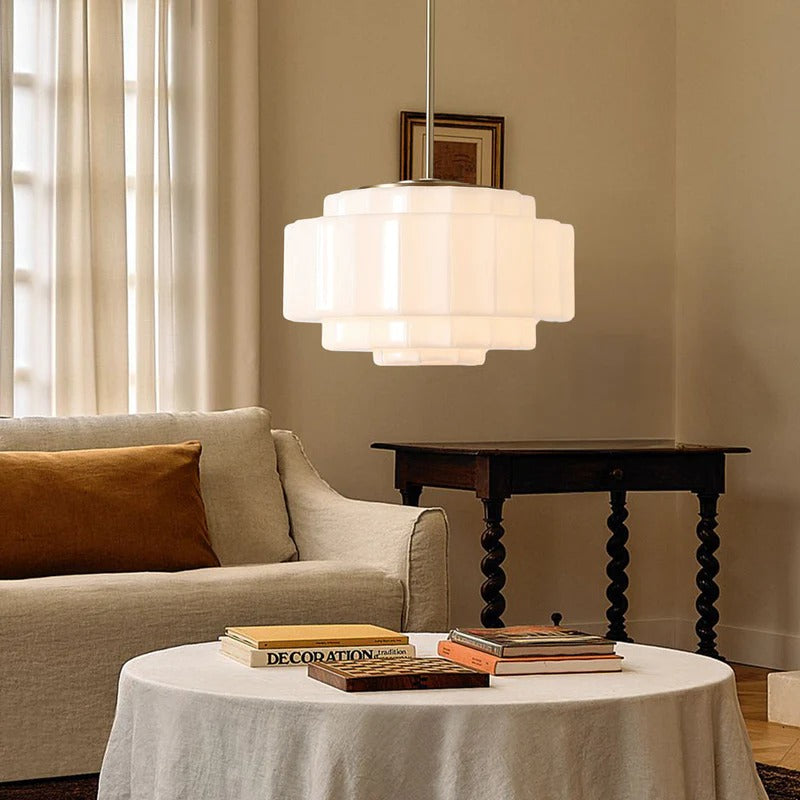 Living room with a beige sofa, round table, and pendant light.