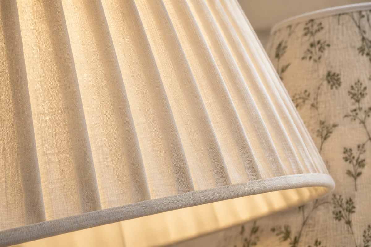 Natural cotton shade wall light beside a bed