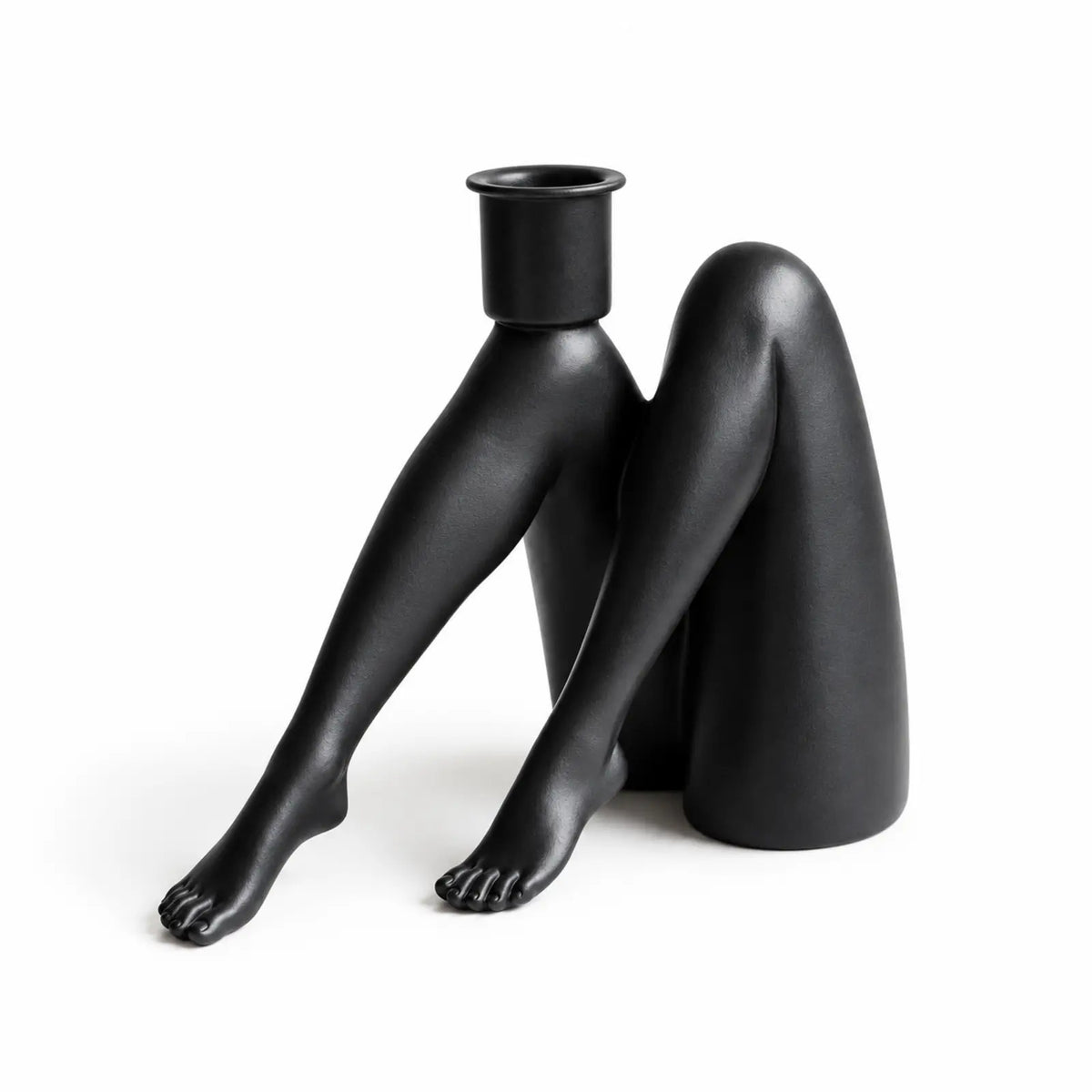 Black bent-leg sculptural figurine candle holder on white background