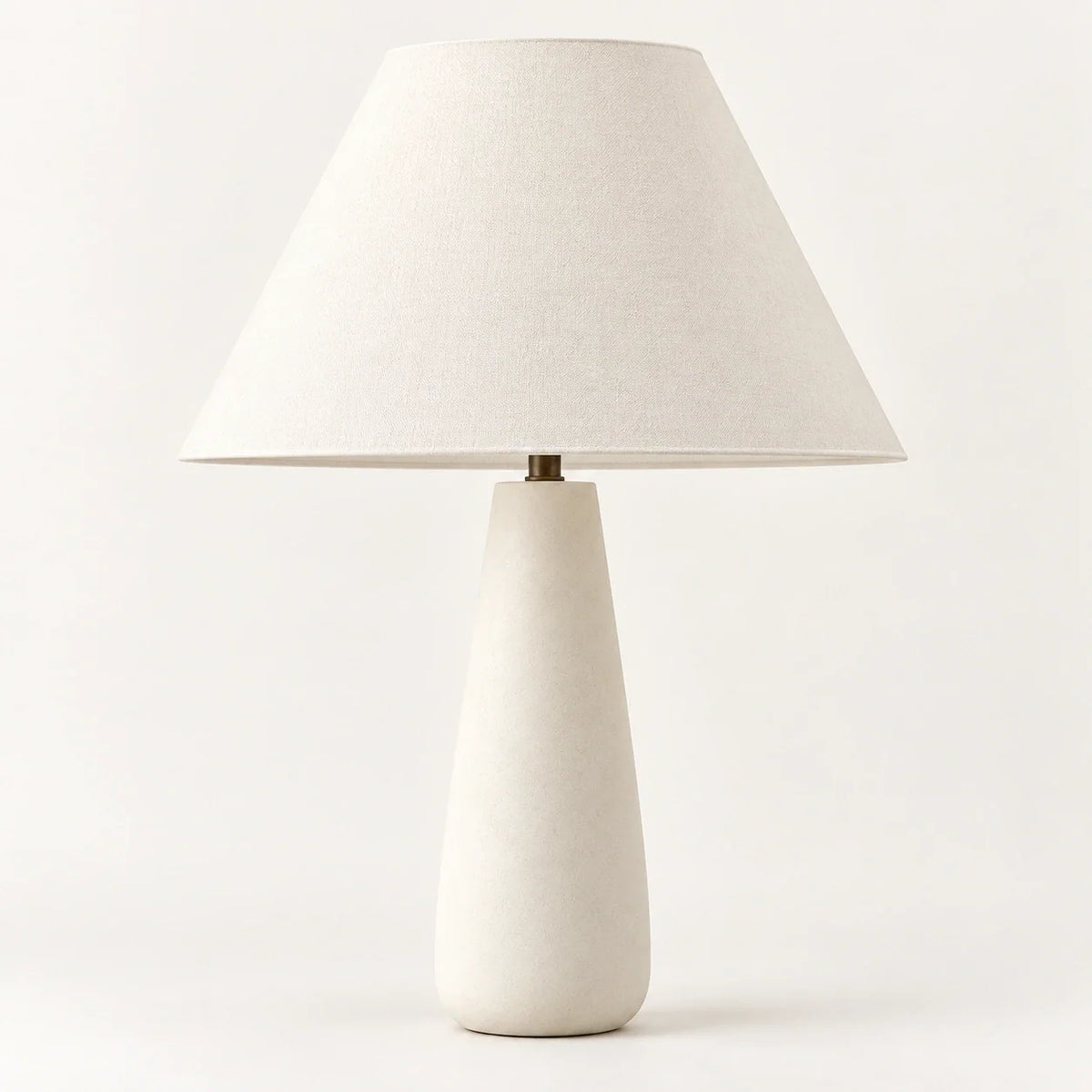 White concrete tapered table lamp with cream textile lampshade, studio view