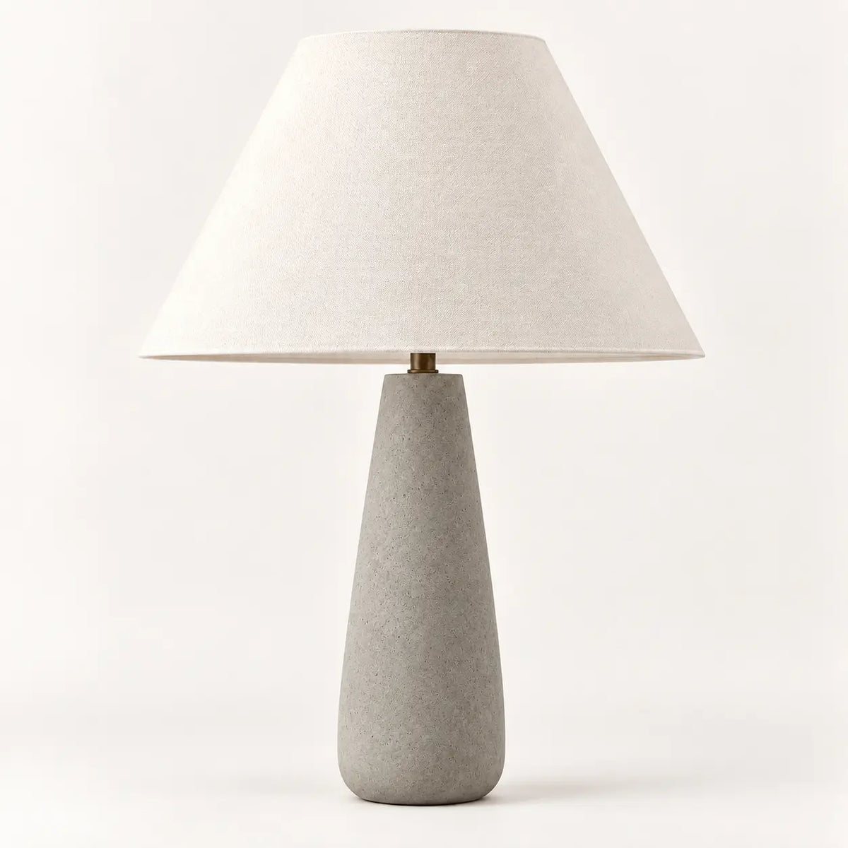 Concrete grey tapered table lamp with cream textile lampshade, studio view