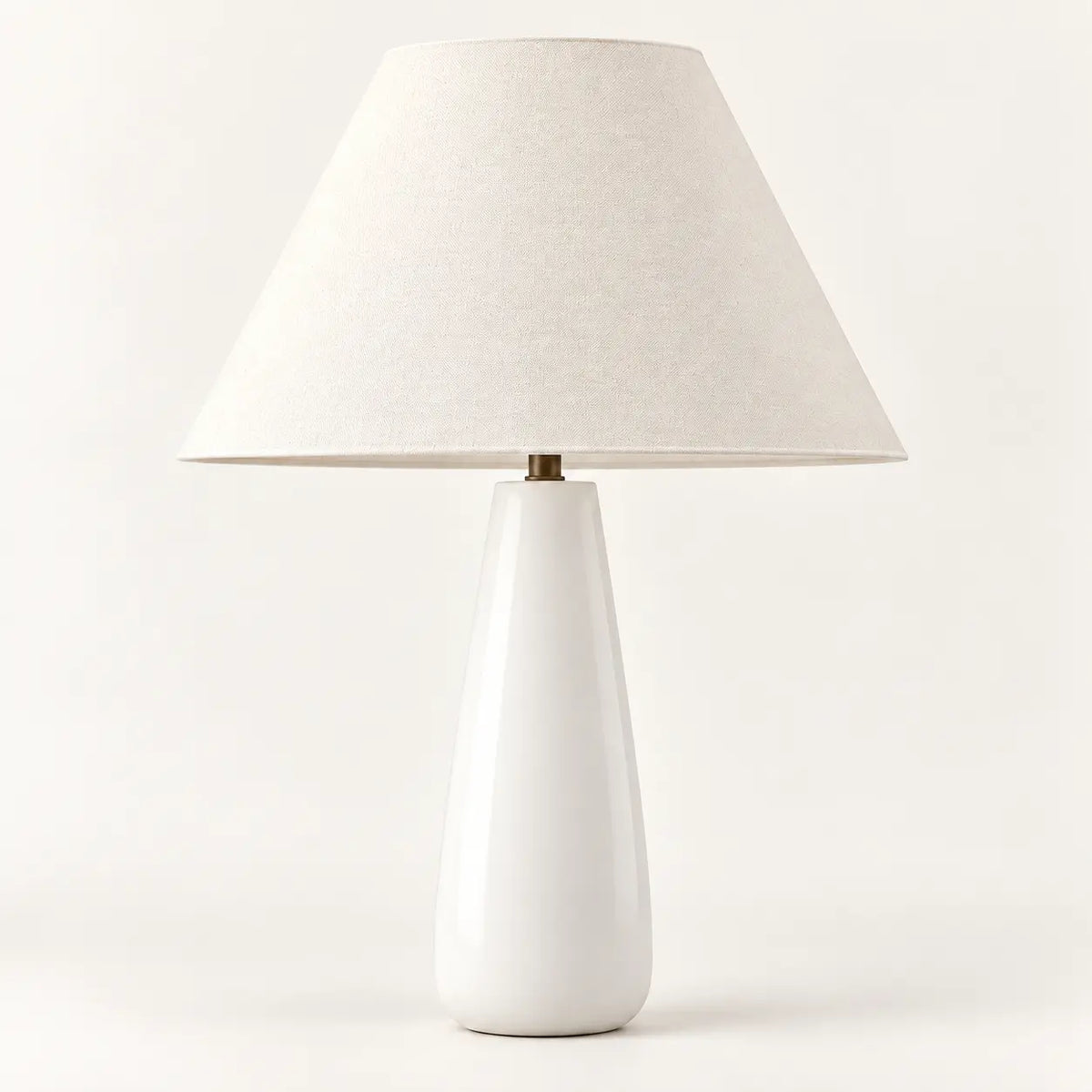 Ceramic white tapered table lamp with cream textile lampshade, studio view