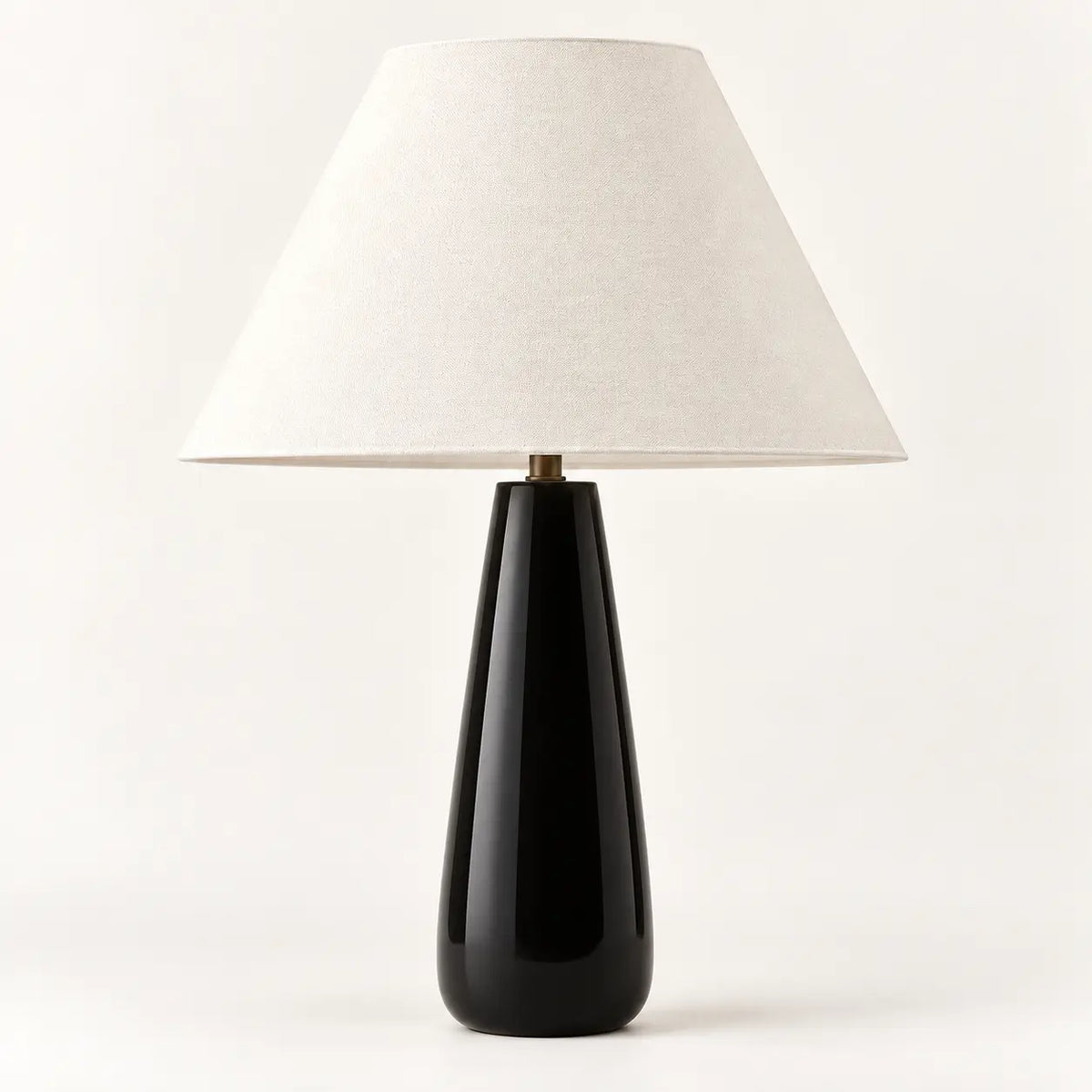 Ceramic black tapered table lamp with cream textile lampshade, studio view