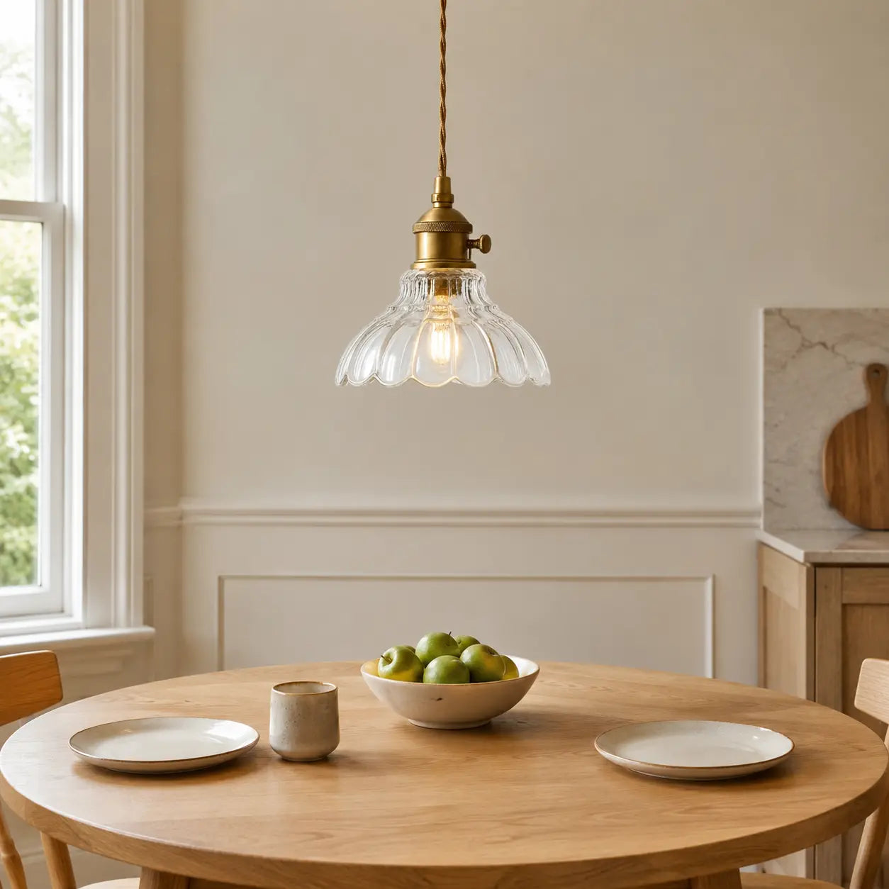 Clear scalloped flower glass pendant light above a round oak breakfast table