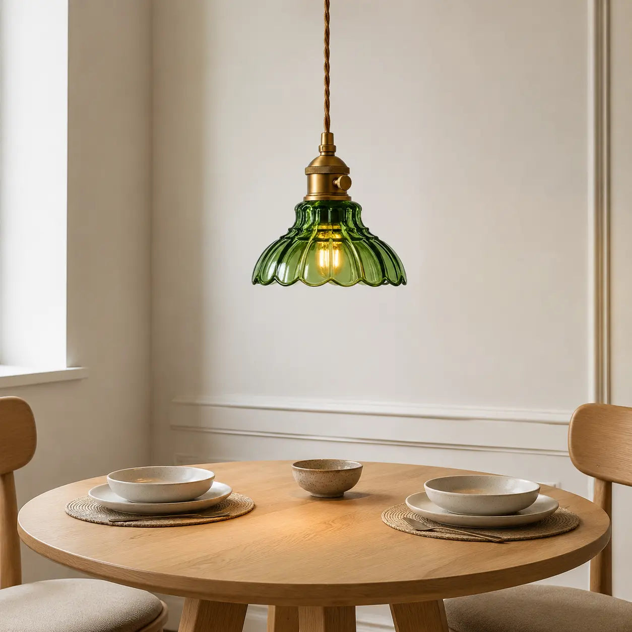 Green scalloped glass pendant light above a round breakfast table