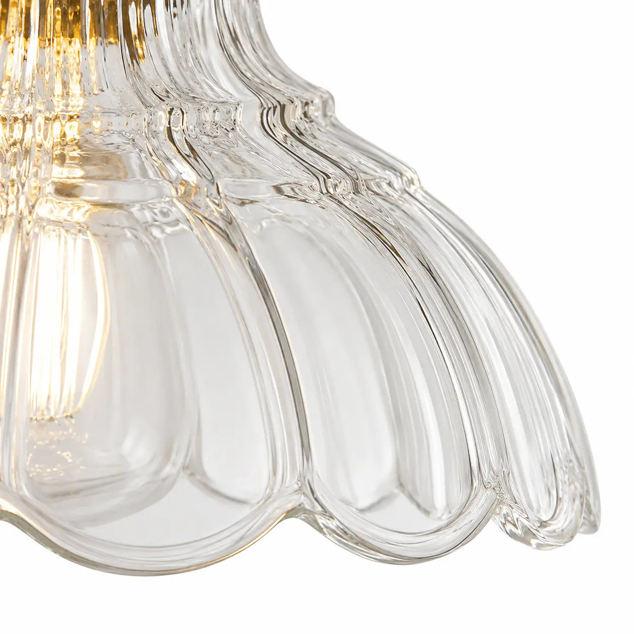 Close detail of clear scalloped pressed glass and vertical fluting